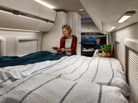 Ein Mann sitzt am Tisch und eine Frau steht am Bett des Grand Californias